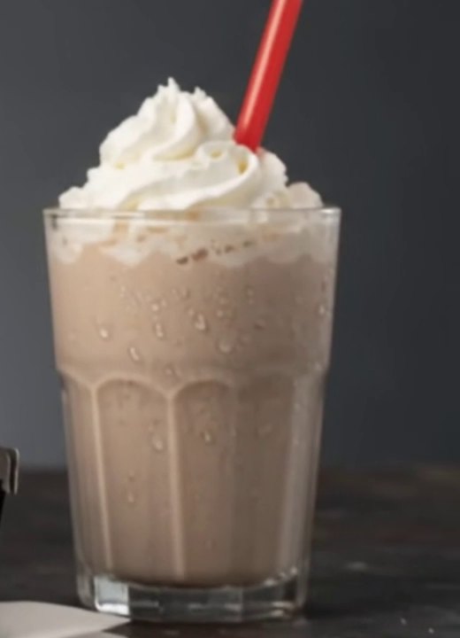 Chocolate milkshake with whipped cream and a red straw